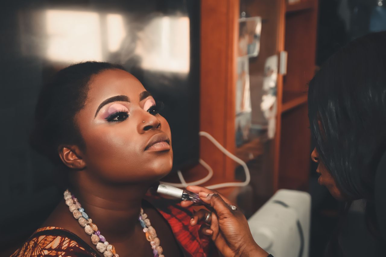 A woman receiving a professional makeup session in a beauty salon. Enhances facial features with a touch of elegance.