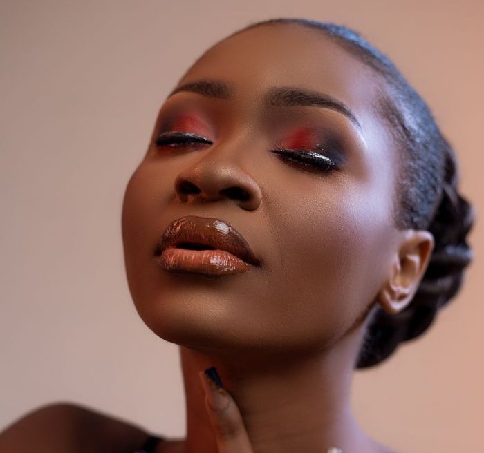 Portrait of a woman with elegant makeup and closed eyes, exuding glamour and confidence.