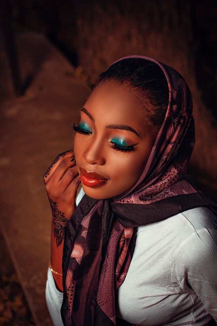 Beautiful portrait of a woman with vibrant makeup and intricate henna design, exuding elegance.